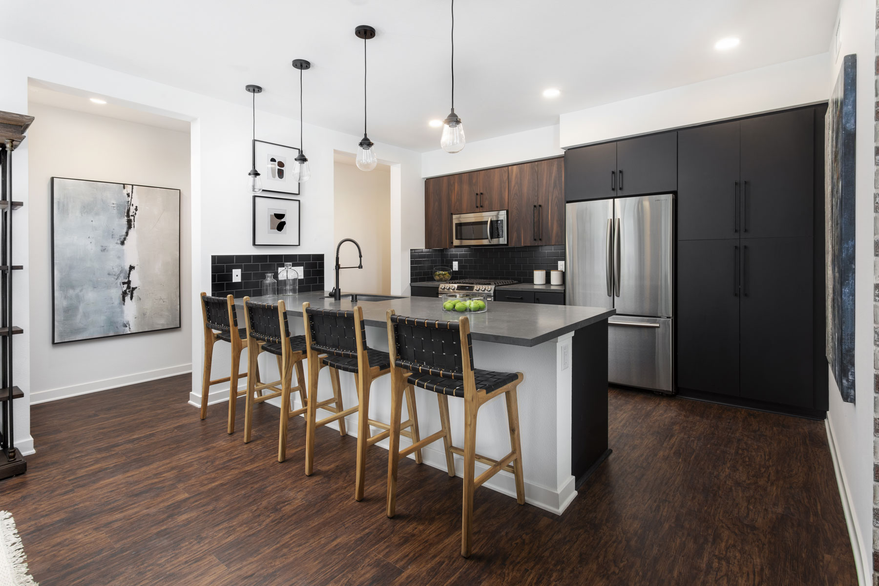 Artistry modern kitchen with black cabinetry and stainless steel appliances at Broadstone Archive Apartments